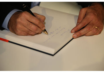 Elio Sassine signs his book “One Flew Over the Cuckoo’s Land”