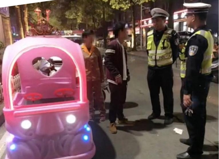 In video: A woman is pulled after driving a toy car on a busy road
